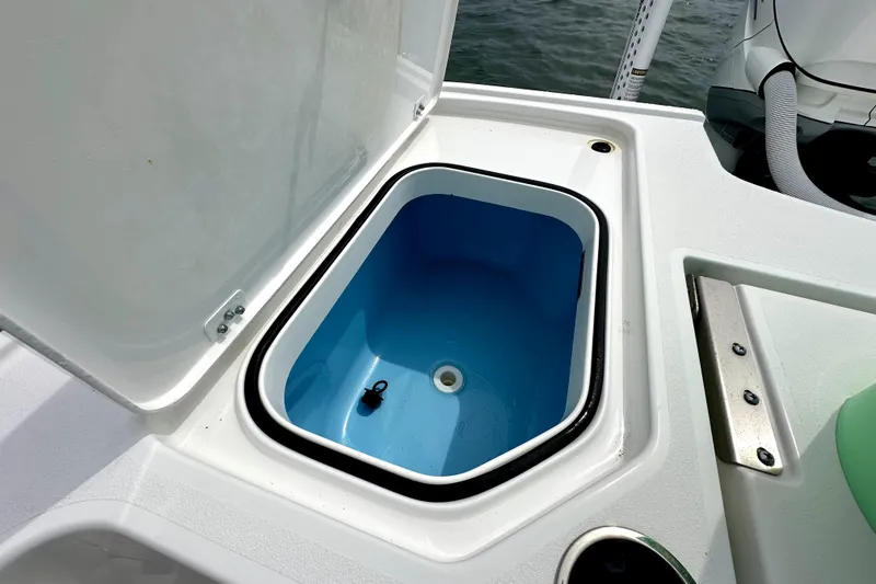 Slide: The Image of Open storage compartment on 2020 Caymas 26 HB boat, featuring a blue interior. - 12