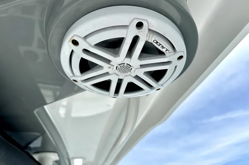Slide: The Image of JL Audio speaker on 2020 Caymas 26 HB boat, under clear blue sky. - 13