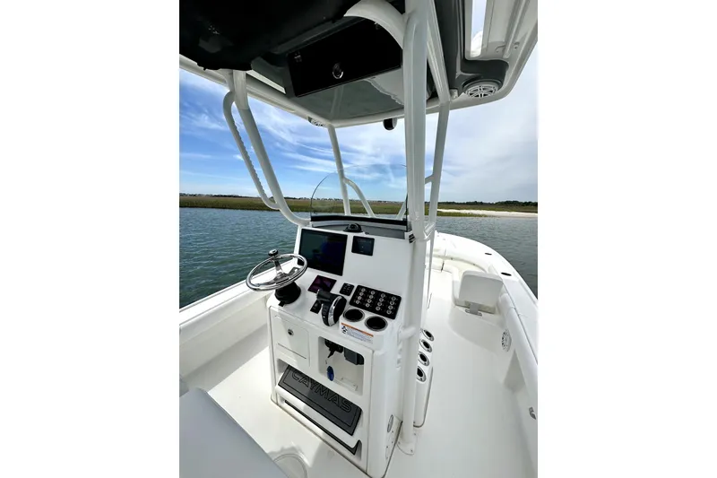 Slide: The Image of 2020 Caymas 26 HB boat helm with steering wheel and control panel on open water. - 16
