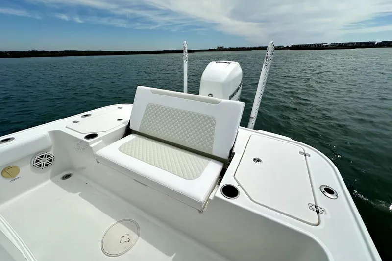 Slide: The Image of 2020 Caymas 26 HB boat with cushioned seating, on calm water under a partly cloudy sky. - 20