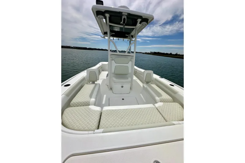 Slide: The Image of 2020 Caymas 26 HB boat with cushioned seating, on calm water under a partly cloudy sky. - 22