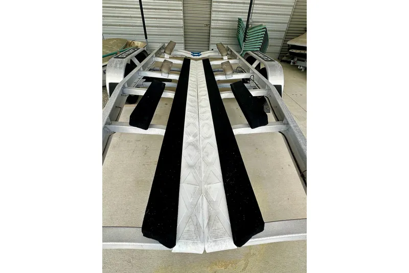 Slide: The Image of Trailer for 2020 Caymas 26 HB boat, featuring black padded supports. - 32
