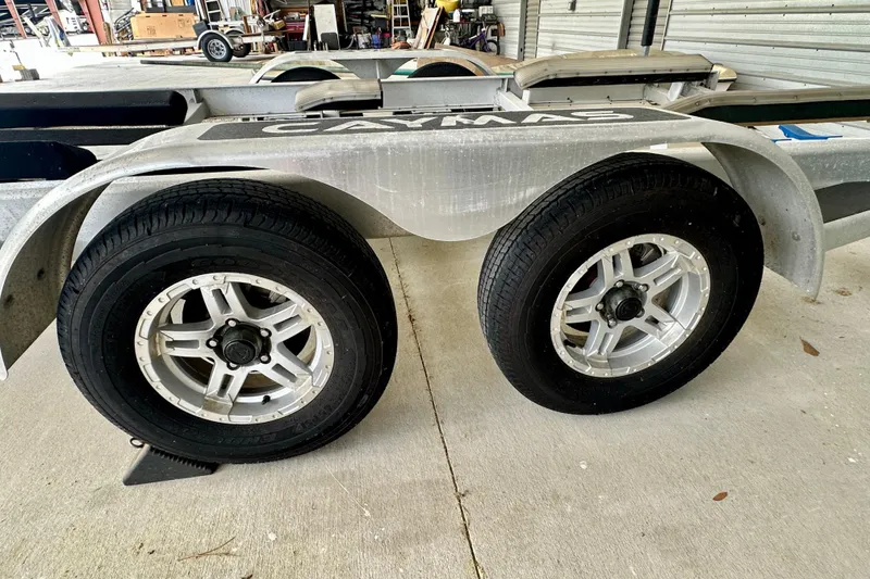 Slide: The Image of Trailer wheels of a 2020 Caymas 26 HB boat on concrete surface. - 33