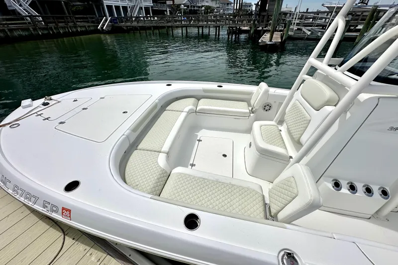 Slide: The Image of 2020 Caymas 26 HB boat with white seating, docked by the water. - 8