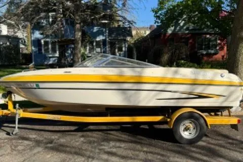 The Image of 2007 Glastron GT 205 boat on trailer, parked outdoors in a residential area. - 0
