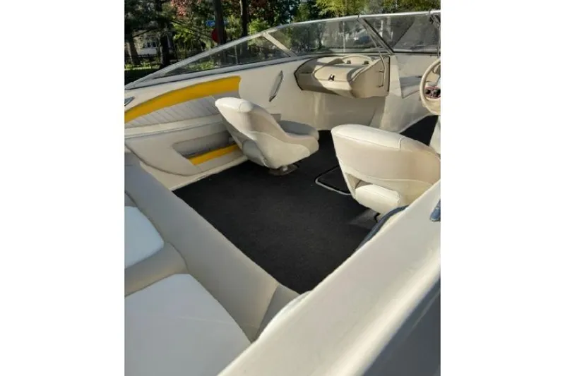 Slide: The Image of 2007 Glastron GT 205 boat interior with white and yellow seating, steering wheel, and dashboard. - 11