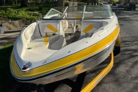 Slide: The Image of 2007 Glastron GT 205 boat with yellow and white design on a trailer. - 2