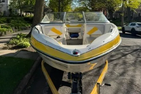 Slide: The Image of 2007 Glastron GT 205 boat with yellow accents parked on a street. - 6