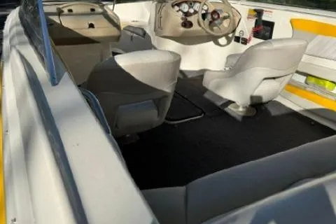 Slide: The Image of 2007 Glastron GT 205 boat interior with white and yellow seating, steering console, and carpeted floor. - 9