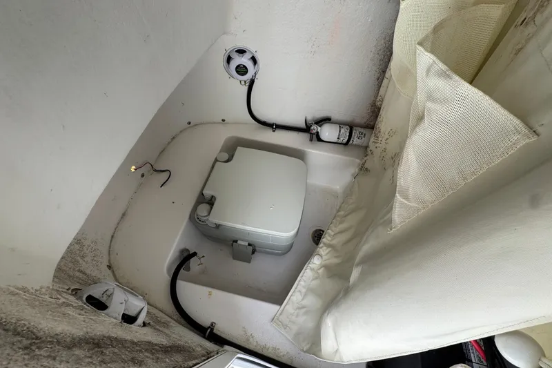 Slide: The Image of 2020 Tidewater 198 CC Adventure boat interior with portable toilet and storage area. - 11