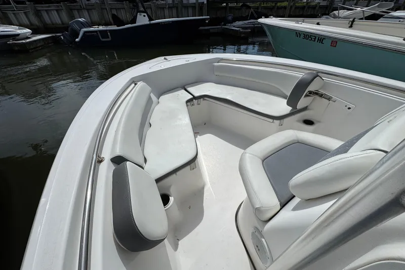 Slide: The Image of 2020 Tidewater 198 CC Adventure boat interior with cushioned seating in a marina. - 13