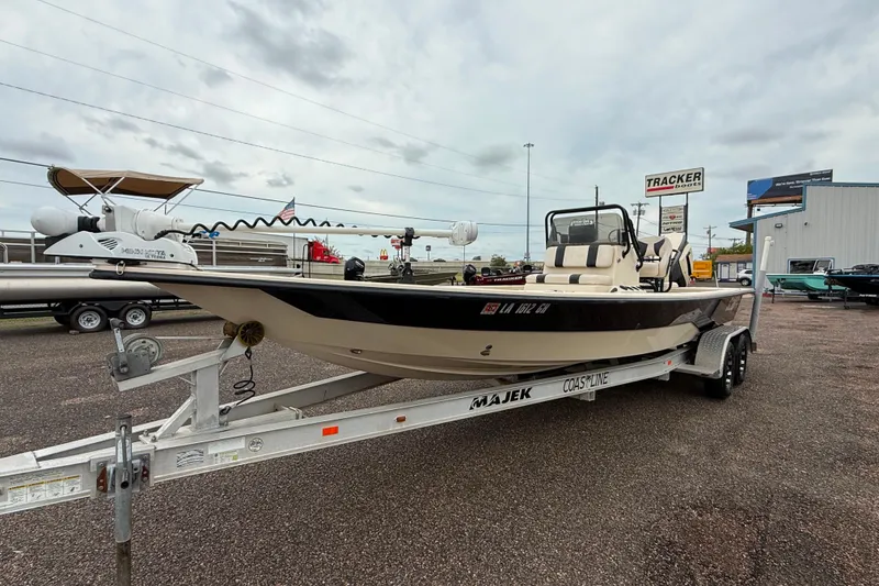 Slide: The Image of 2017 Majek 25 Xtreme boat on trailer at dealership, overcast sky. - 1