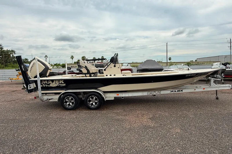 Slide: The Image of 2017 Majek 25 Xtreme boat on trailer, parked outdoors under cloudy sky. - 2