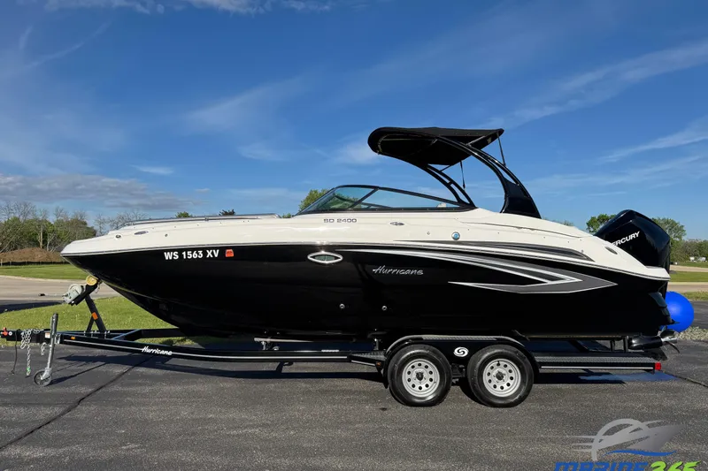 The Image of 2025 Hurricane SunDeck 2400 OB boat on trailer under clear blue sky. - 0