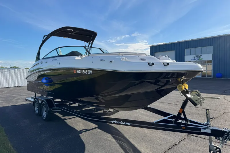 Slide: The Image of 2025 Hurricane SunDeck 2400 OB boat on trailer, parked outdoors under clear sky. - 1