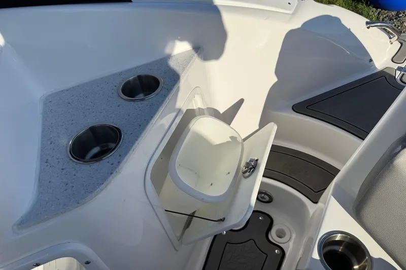 Slide: The Image of 2025 Hurricane SunDeck 2400 OB boat interior with cup holders and storage compartment. - 14