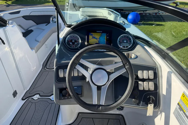 Slide: The Image of 2025 Hurricane SunDeck 2400 OB boat dashboard with steering wheel and navigation display. - 16
