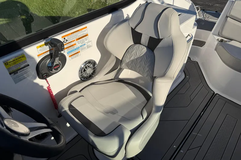 Slide: The Image of Captain's seat in 2025 Hurricane SunDeck 2400 OB boat, featuring ergonomic design and control panel. - 20
