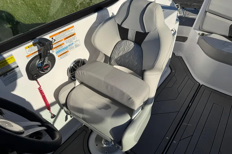 Slide: The Image of Captain's seat on 2025 Hurricane SunDeck 2400 OB boat, featuring ergonomic design and controls. - 21