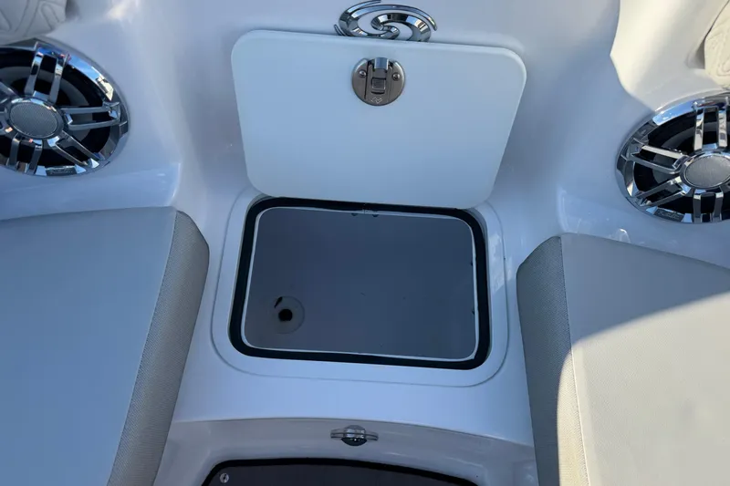 Slide: The Image of 2025 Hurricane SunDeck 2400 OB boat interior with storage compartment and speakers. - 25