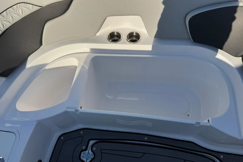 Slide: The Image of 2025 Hurricane SunDeck 2400 OB boat interior with storage compartment and cup holders. - 29