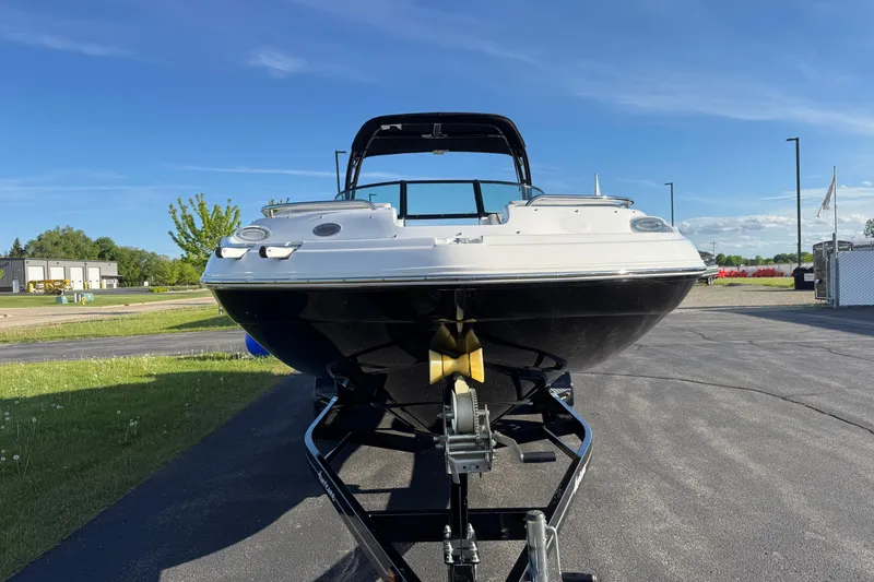 Slide: The Image of 2025 Hurricane SunDeck 2400 OB boat on trailer, parked outdoors under clear blue sky. - 3