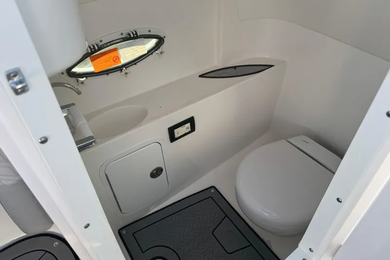 Slide: The Image of 2025 Hurricane SunDeck 2400 OB boat interior bathroom with toilet and sink. - 32
