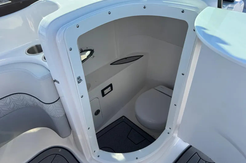 Slide: The Image of 2025 Hurricane SunDeck 2400 OB boat interior with compact marine toilet. - 33