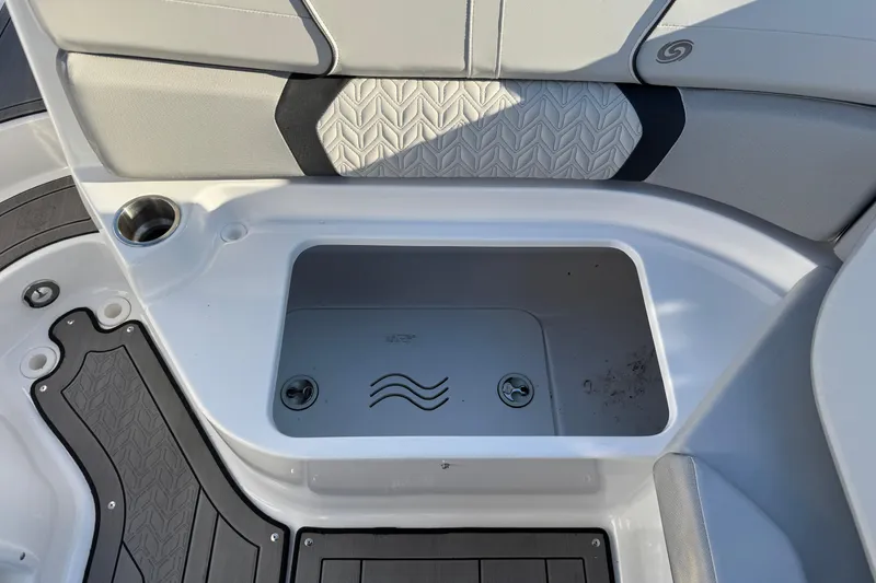 Slide: The Image of 2025 Hurricane SunDeck 2400 OB boat storage compartment with sleek design and cup holder. - 37