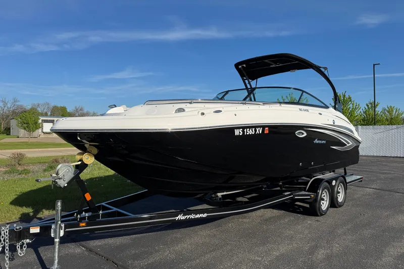 Slide: The Image of 2025 Hurricane SunDeck 2400 OB boat on trailer under clear blue sky. - 4