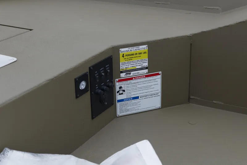 Slide: The Image of Control panel and safety labels on 2026 G3 Gator Tough 18 DK boat interior. - 10