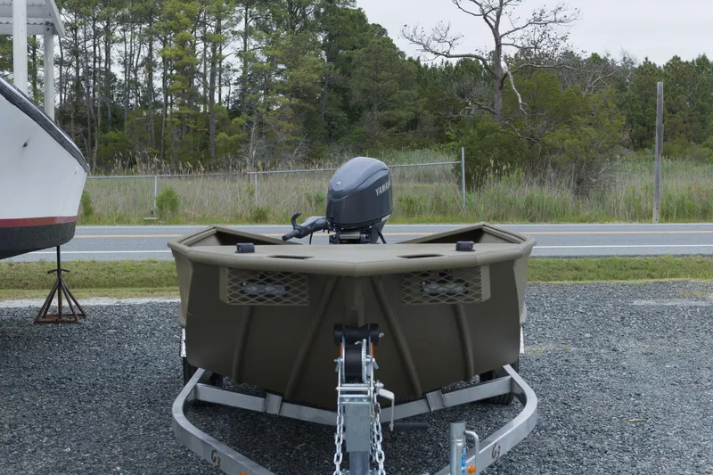 Slide: The Image of 2026 G3 Gator Tough 18 DK boat on trailer, parked outdoors near trees. - 4