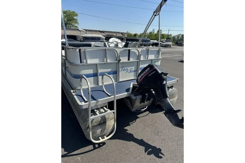 Slide: The Image of Pontoon boat Playtime DL2022, 2002 model, with Mercury outboard motor in parking lot. - 4