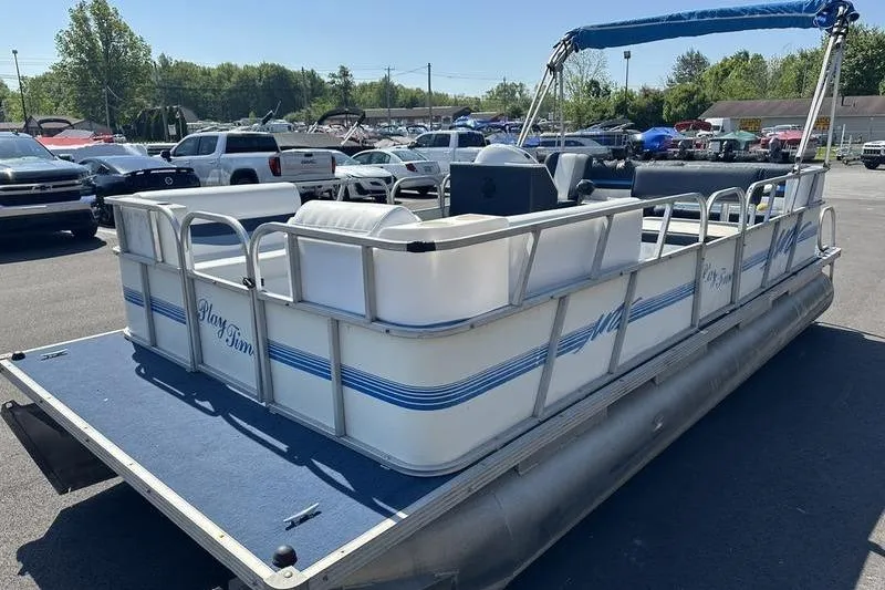 Slide: The Image of 2002 Playtime DL2022 pontoon boat with blue accents in a parking lot. - 7