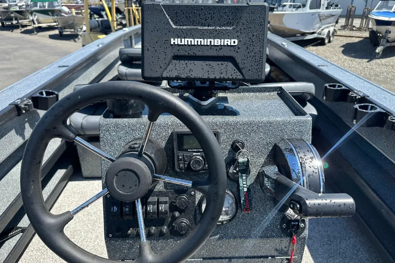 Slide: The Image of 2024 Alumaweld Columbia 25 boat dashboard with steering wheel and Humminbird navigation system. - 8