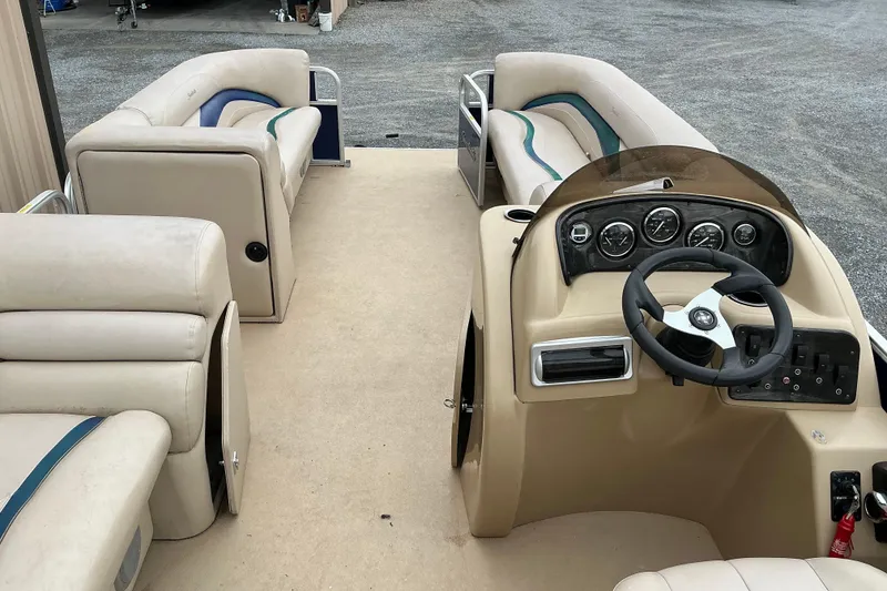 Slide: The Image of 2012 Godfrey Sweetwater 2486 C pontoon boat interior with beige seating and steering console. - 8
