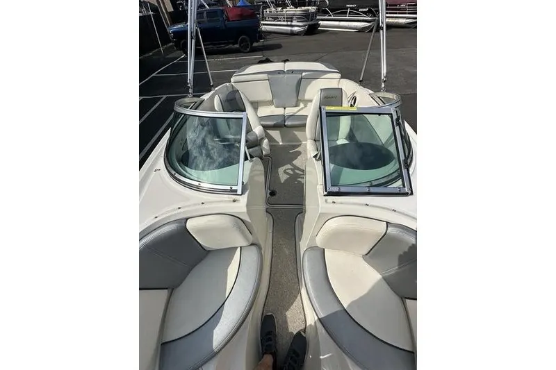 Slide: The Image of 2008 Sea Ray 185 Bow Rider interior with white and gray seating, parked outdoors. - 14