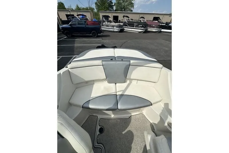 Slide: The Image of 2008 Sea Ray 185 Bow Rider interior with white and gray seating in a parking lot. - 6