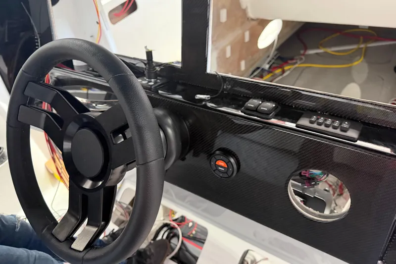 Slide: The Image of Steering wheel and dashboard of 2027 Nor-Tech 390 Sport Center Console boat. - 14
