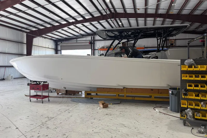 Slide: The Image of 2027 Nor-Tech 390 Sport Center Console boat in a workshop setting. - 3