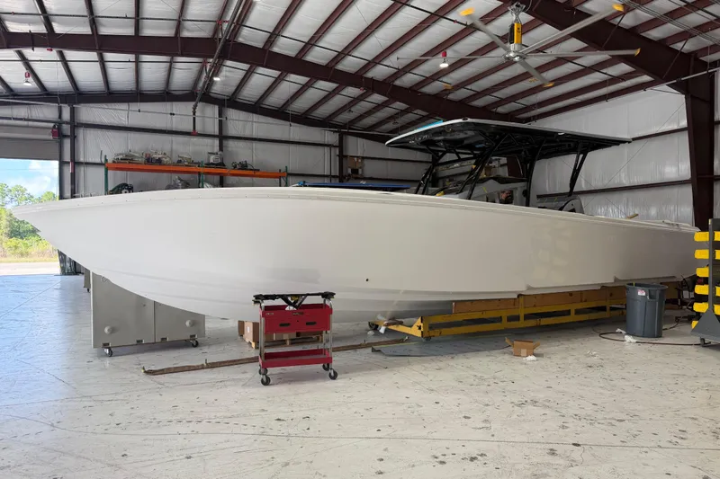 Slide: The Image of 2027 Nor-Tech 390 Sport Center Console boat in a spacious indoor facility. - 4