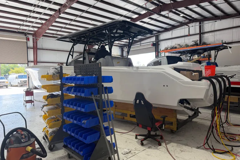 Slide: The Image of 2027 Nor-Tech 390 Sport Center Console in a workshop setting. - 5