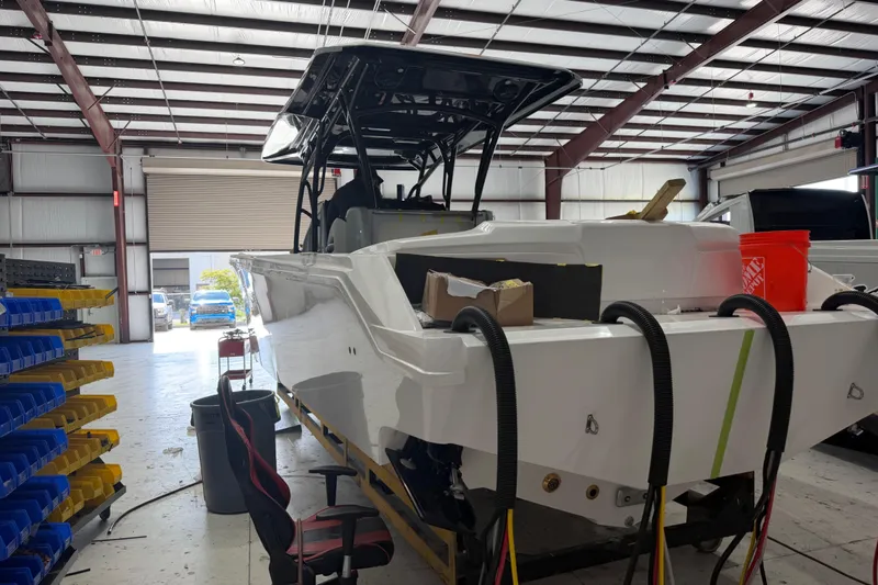 Slide: The Image of 2027 Nor-Tech 390 Sport Center Console boat in a warehouse under construction. - 6