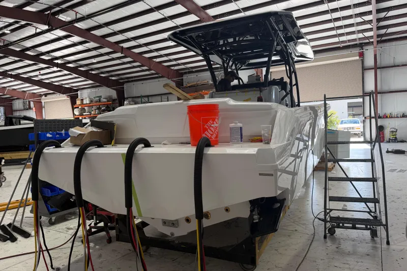 Slide: The Image of 2027 Nor-Tech 390 Sport Center Console boat in a workshop, under construction. - 8