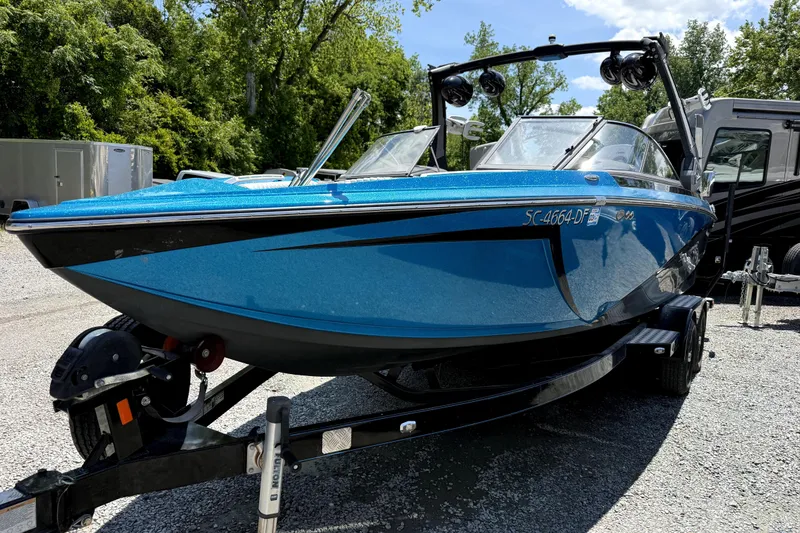 Slide: The Image of 2017 Tigé Z3 boat in vibrant blue on a trailer, parked outdoors. - 2