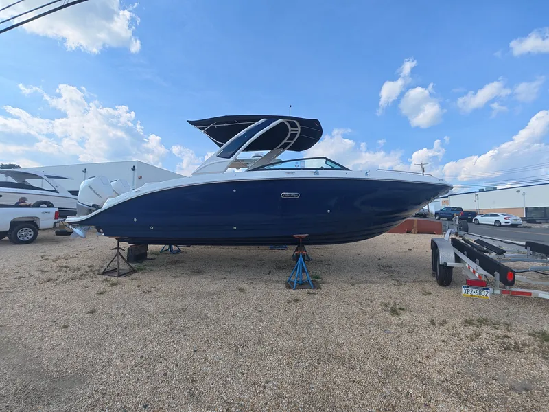Slide: The Image of A 2027 Sea Ray SDX 290 Outboard is on a gravel lot. It features a sleek, modern design. - 0