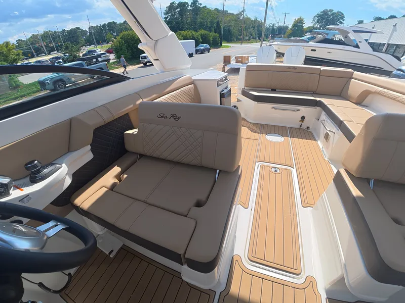 Slide: The Image of The image shows the cockpit of a Sea Ray SDX 290 Outboard with beige upholstery and wood flooring. - 18