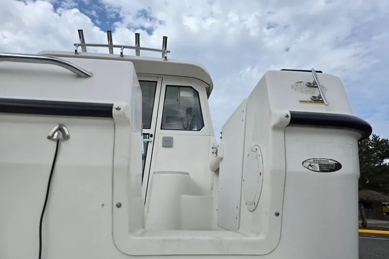 Slide: The Image of 2006 Trophy 2359 Pro boat, rear view, showcasing cabin entrance and fishing rod holders. - 14
