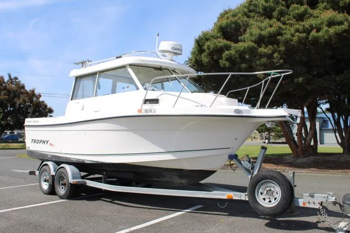 Slide: The Image of 2006 Trophy 2359 Pro boat on trailer, parked outdoors near trees. - 2