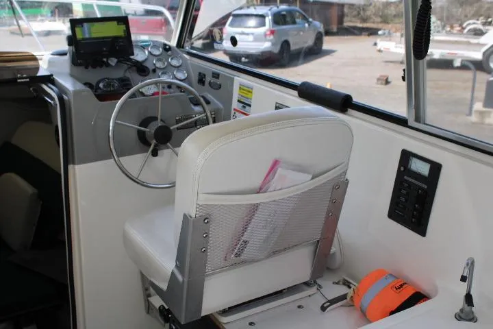 Slide: The Image of Interior of a 2006 Trophy 2359 Pro boat with steering wheel and navigation equipment. - 24